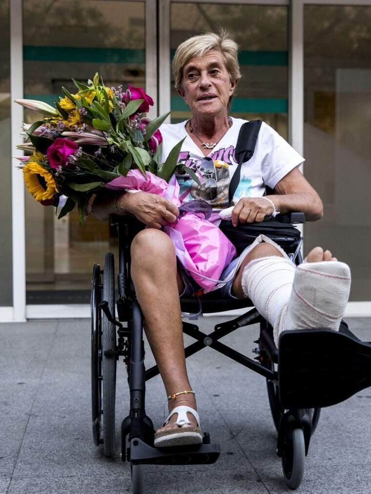 Chelo García Cortés en silla de ruedas con flores en la mano y el pie escayolado
