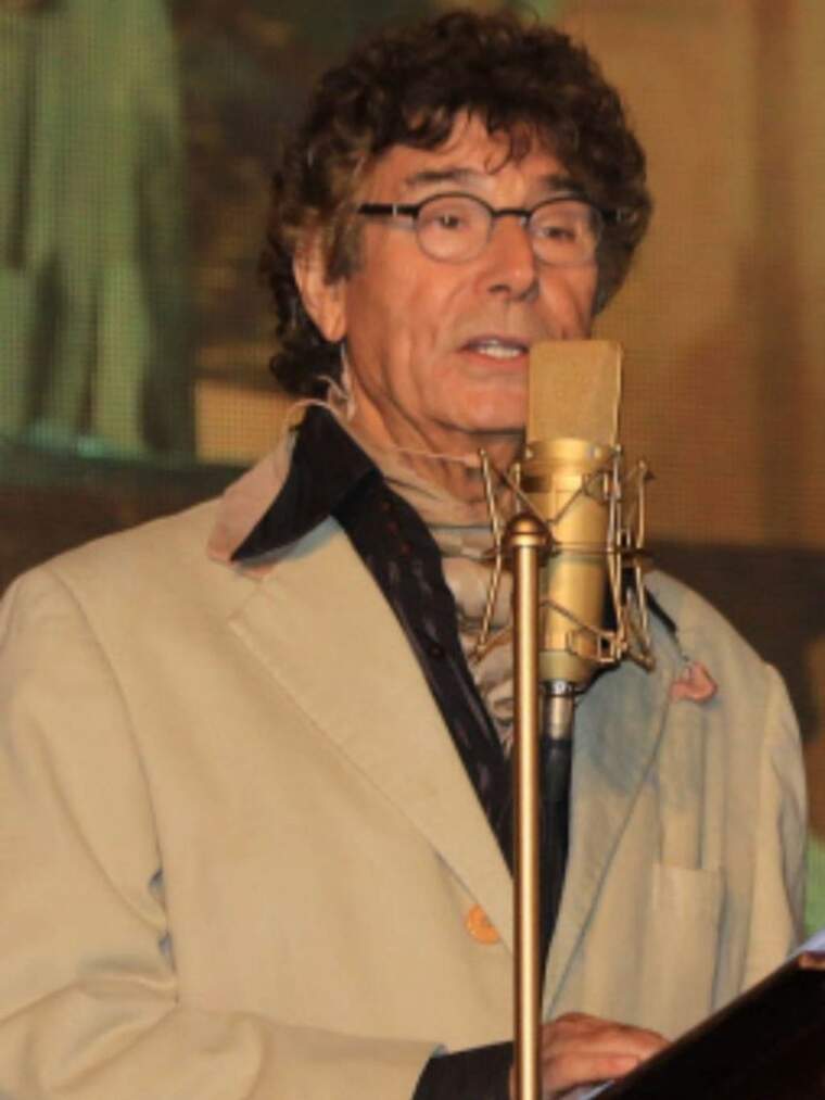 Jesús Quintero con una chaqueta de color gris hablando ante un micrófono