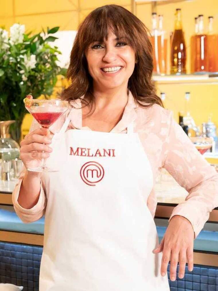 Melani Olivares con un delantal de 'MasterChef' blanco con su nombre y una copa en la mano