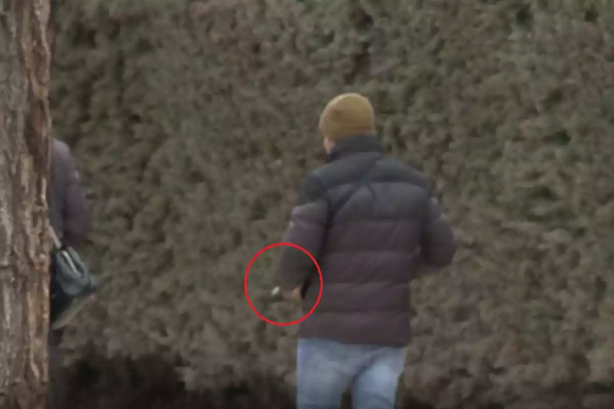 José Fernando Ortega con un cigarrillo en la mano andando por la calle de espaldas José Fernando Ortega con un cigarrillo en la mano andando por la calle de espaldas
