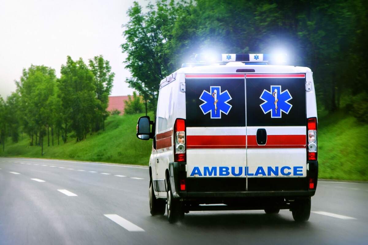 Una ambulancia francesa con luces de emergencia encendidas en la carretera