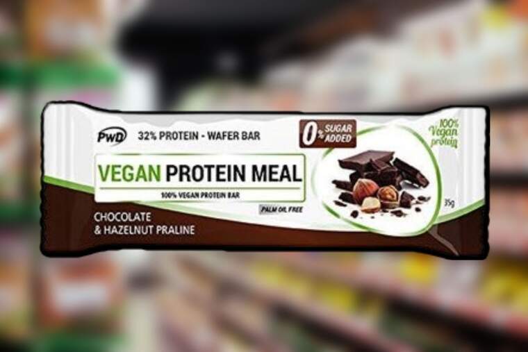 Una barrita de proteínas veganas con supermercado de fondo