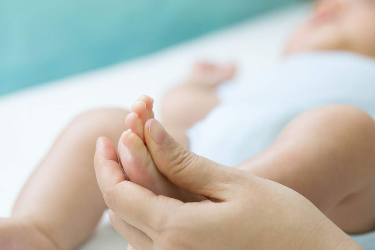 Persona masajeando el pie de un niño pequeño