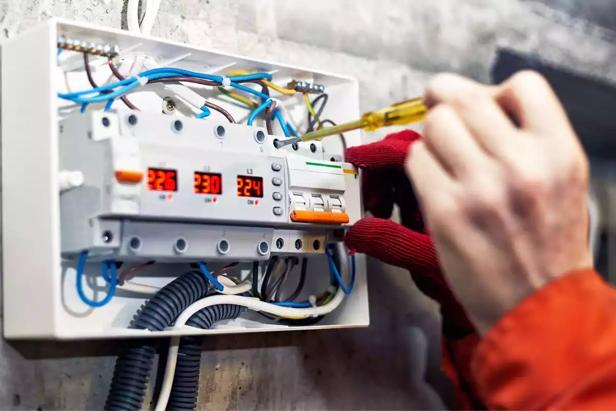 Imágen de un técnico reparando un cuadro de luces Imágen de un técnico reparando un cuadro de luces