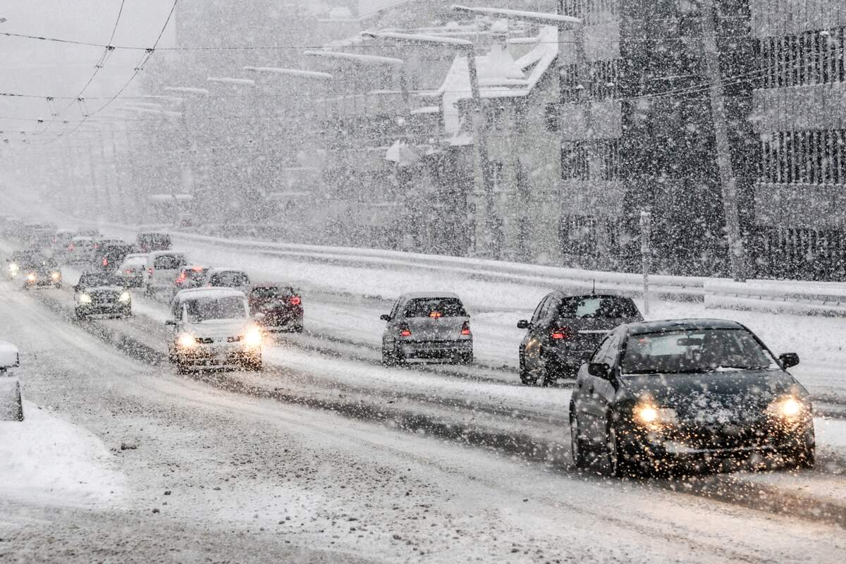 Coches circulando con un temporal de nieve