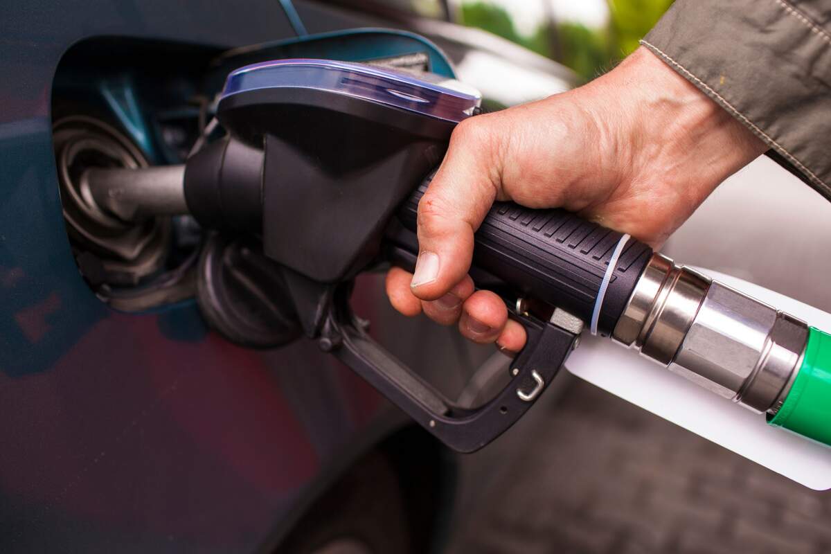 Imágen de una persona repostando en una gasolinera Imágen de una persona repostando en una gasolinera