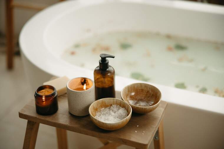 Filled bathtub with petals and candles