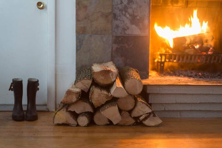 Fireplace with wood stack and rain boots by the door
