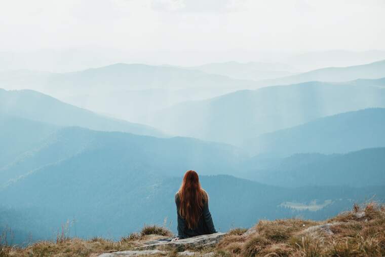 Girl enjoying the view from the top of a mountain