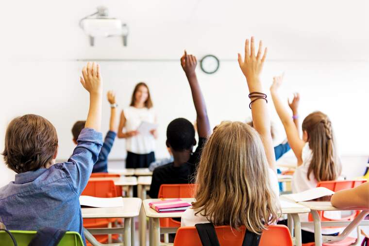 Unos niños levantando la mano en una clase