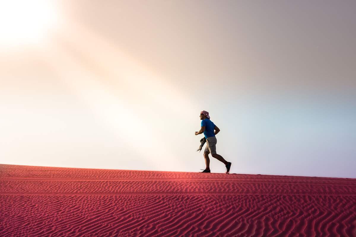 Hombre corriendo por las dunas de un desierto