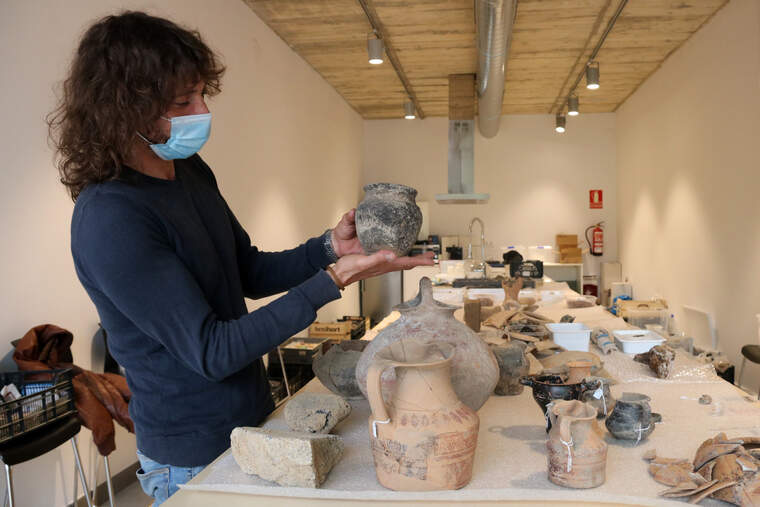 L'arqueòleg Dani López mostrant una peca de ceràmica sencera trobada al jaciment Font de la Canya