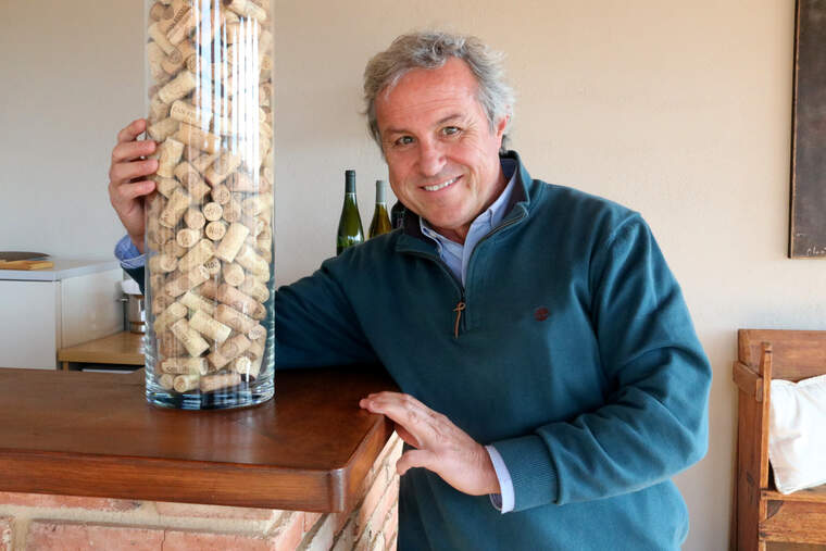 El president de la DO Penedès, Joan Huguet, abraçant un gerro ple de taps de vi