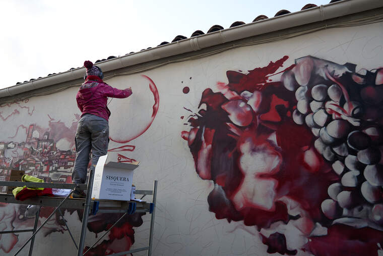 L'artista lleidatana rematant la pintura a la paret de Cellers Tarroné