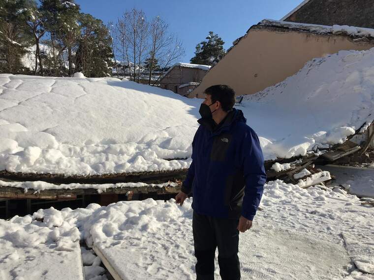 Roger Simó de Vall Llach al costat de la teulada esfondrada per la neu