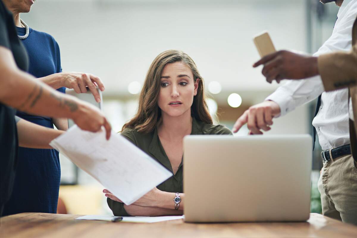 Mujer preocupada en el trabajo por la cantidad de tareas que tiene que hacer Mujer preocupada en el trabajo por la cantidad de tareas que tiene que hacer