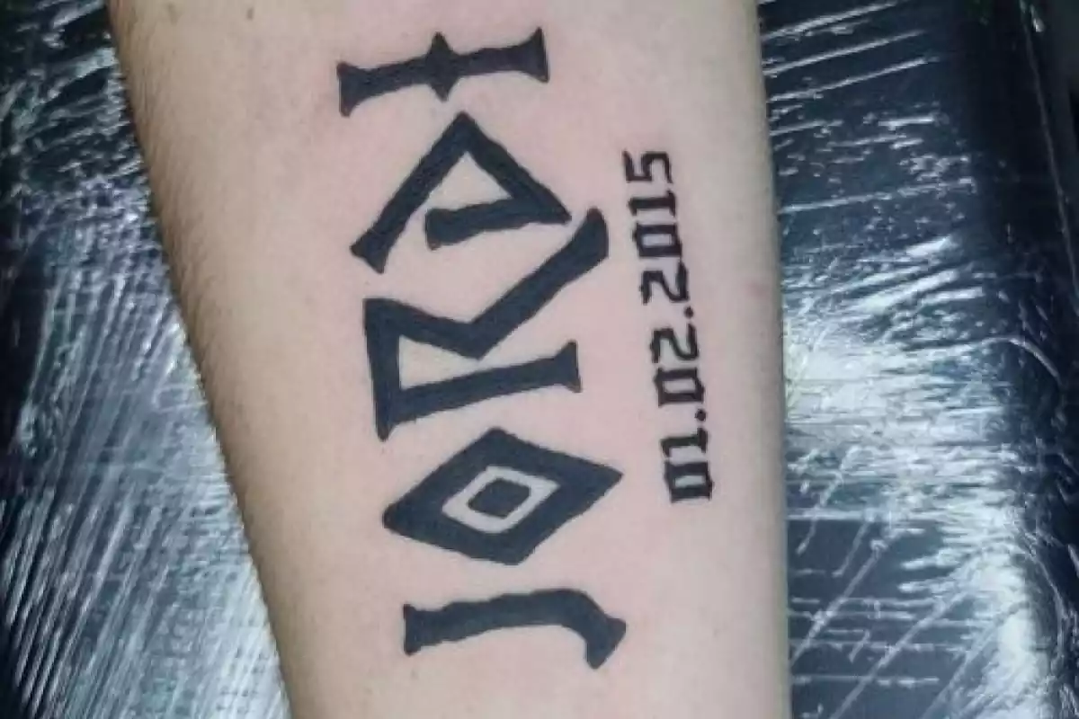 Diseño de tatuaje de nombre con letras griegas con fecha en el brazo y en negro Diseño de tatuaje de nombre con letras griegas con fecha en el brazo y en negro