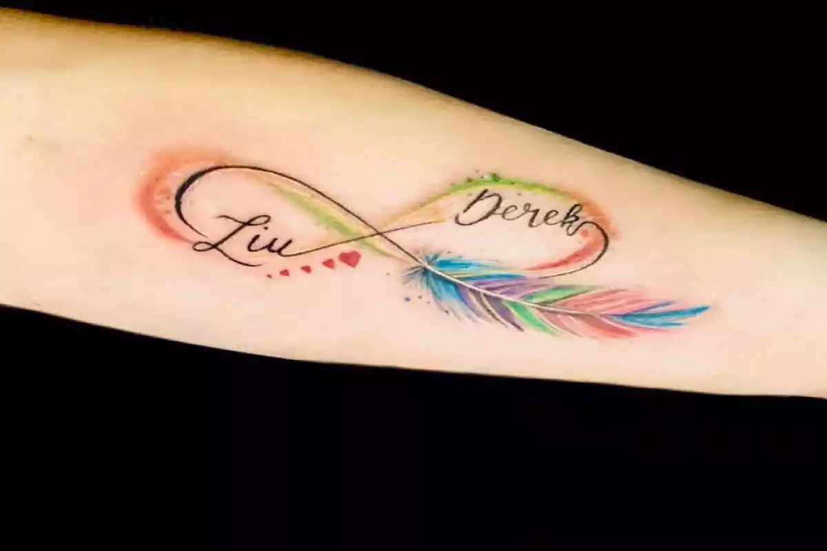 Foto de un brazo con un tatuaje de un símbolo del infinito con dos nombres y una pluma y colores de estilo acuarela Foto de un brazo con un tatuaje de un símbolo del infinito con dos nombres y una pluma y colores de estilo acuarela