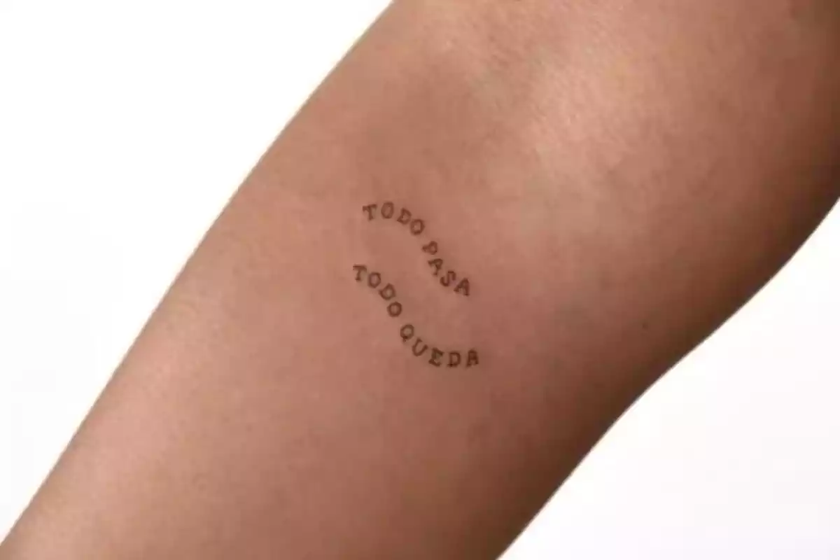 Foto detalle de un brazo en el que aparece en pequeño el tatuaje de la frase 'Todo pasa todo queda' Foto detalle de un brazo en el que aparece en pequeño el tatuaje de la frase 'Todo pasa todo queda'