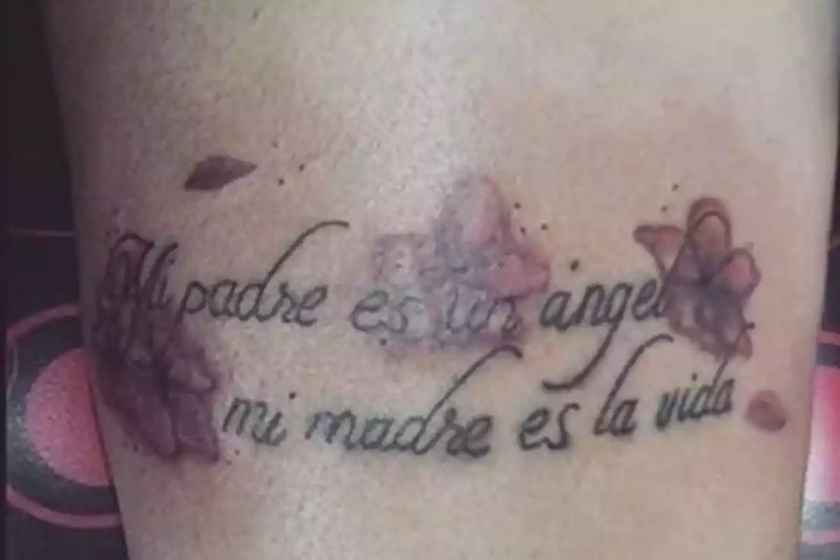 Foto detalle de un tatuaje en un muslo en el que aparece la frase 'Mi padre es un ángel, mi madre es la vida' Foto detalle de un tatuaje en un muslo en el que aparece la frase 'Mi padre es un ángel, mi madre es la vida'