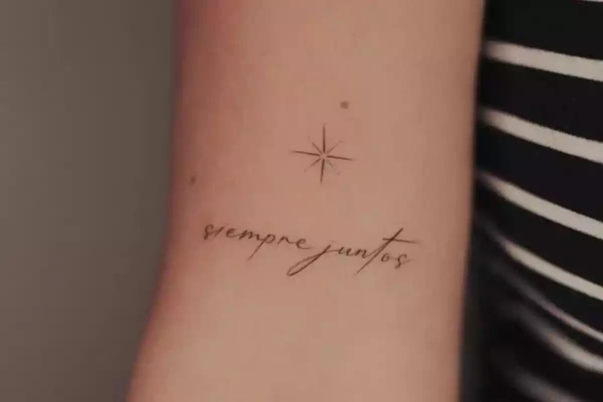 Foto recortada de un brazo en el que aparece un tatuaje de una estrella y la frase 'Siempre juntos' Foto recortada de un brazo en el que aparece un tatuaje de una estrella y la frase 'Siempre juntos'