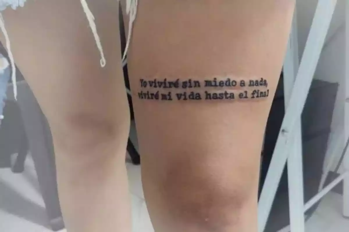 Foto recortada de una pierna en la que se ven dos muslos, uno de ellos con la frase tatuada 'Yo viviré sin miedo a nada, viviré mi vida hasta el final' Foto recortada de una pierna en la que se ven dos muslos, uno de ellos con la frase tatuada 'Yo viviré sin miedo a nada, viviré mi vida hasta el final'