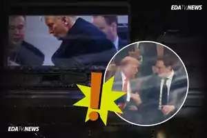 Dos hombres conversan y se dan la mano en un evento, con un símbolo de exclamación amarillo en el centro de la imagen.