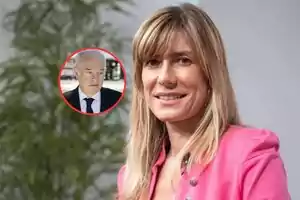 Mujer rubia con chaqueta rosa sonríe mientras al fondo aparece un círculo con la imagen de un hombre mayor de cabello canoso y traje oscuro